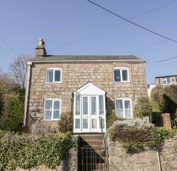 A stone house with four windows and a white porch at Gordons View Pleasant Stile near Gloucester