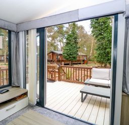 A living room with a view of a deck at Wild Duck Holiday Park in Belton, Norfolk