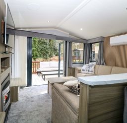 A living room with a sofa and television at Wild Duck Holiday Park in Belton, Norfolk