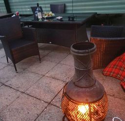a seating area with two chairs and a chiminea on a patio at Hafan y Mor Haven - Holiday Accommodation 11370 in Pwllheli