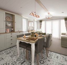 a dining area with a table and chairs, a kitchen cabinet, and a sofa at Perran Sands - Holiday Accommodation 12174 in Perranporth