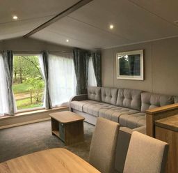 a living room with a sectional sofa and a coffee table at Kelling Heath Holiday Park - Holiday Accommodation 13133 in Holt