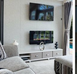 a living room with a television and fireplace on the wall at Ocean Edge Leisure Park - Holiday Accommodation 1317, Heysham
