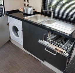 a kitchen area with a washing machine and a dishwasher under the counter at Ocean Edge Leisure Park - Holiday Accommodation 1317, Heysham