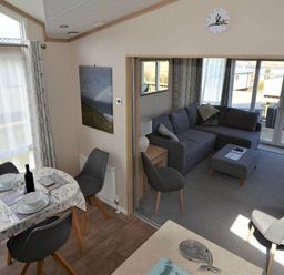 a dining area with a table and chairs overlooking a living room at Perran Sands - Holiday Accommodation 15012, Perranporth