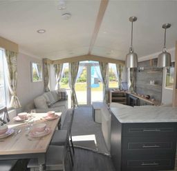 a living room and dining area with a kitchen island at Perran Sands - Holiday Accommodation 15554 in Perranporth