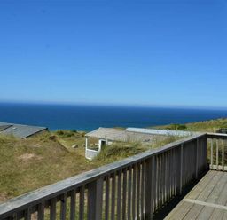 a view of the ocean from a wooden balcony at Perran Sands - Holiday Accommodation 15598 in Perranporth