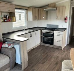 a kitchen with cabinets, a stove, and a sink at Unity Holiday Resort - Holiday Accommodation 15970, Brean Sands