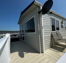 a modular building with a terrace and outdoor seating at Newquay Bay Resort - Holiday Accommodation 15978 in Newquay