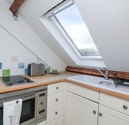 A kitchen with a sink and stove Fastnet at Nonsuch House Kingswear, Devon