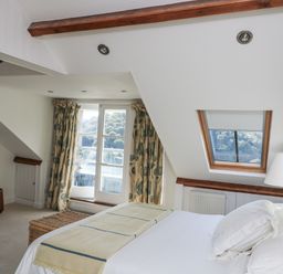 A bedroom with a bed, desk, and window at Fastnet at Nonsuch House, Kingswear, Devon