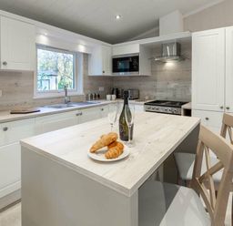 a kitchen with a table featuring croissants and drinks at Kelling Heath Holiday Park - Holiday Accommodation 16221, Holt