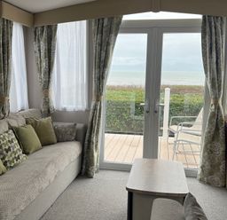 A living room with a sofa and cushions at Hafan y Mor Haven - Holiday Accommodation 16251 in Pwllheli