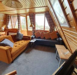 a living room with two sofas, a coffee table, and large windows at Hafan y Mor Haven - Holiday Accommodation 16279 in Pwllheli