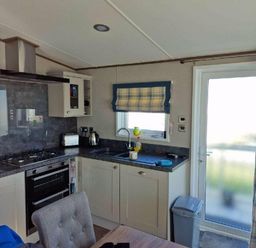a kitchen with a sink, stove, and window at Lakeland Leisure Park - Holiday Accommodation 16942, Flookburgh