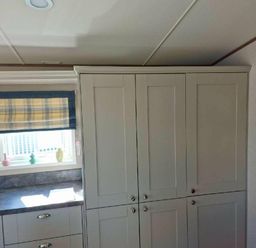 a kitchen area with grey cabinets and a window featuring a checked blind at Lakeland Leisure Park - Holiday Accommodation 16942, Flookburgh