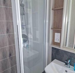 a bathroom featuring a shower with a glass door and a sink cabinet at Lakeland Leisure Park - Holiday Accommodation 16942 in Flookburgh