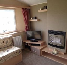 a living room with a sofa, television, and decorative shelves at Butlins Minehead - Holiday Accommodation 1700, Minehead