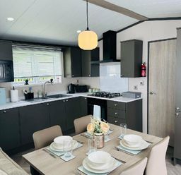 a kitchen with modern cabinetry and a dining table at Ashbourne Heights Holiday Park - Holiday Accommodation 18103 Ashbourne