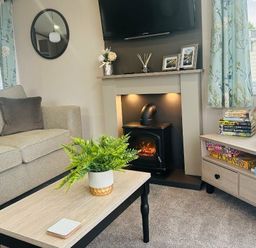 a living room with a sofa, coffee table, and electric fireplace at Ashbourne Heights Holiday Park - Holiday Accommodation 18103, Ashbourne