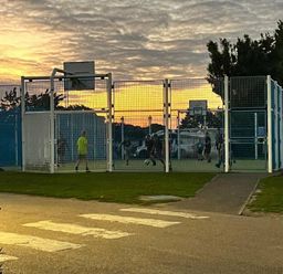a fenced sports court with players engaged in soccer at Breydon Water Holiday Park - Holiday Accommodation 18490, Great Yarmouth