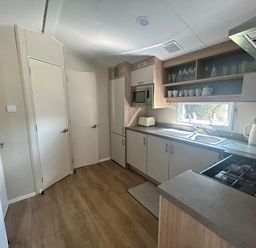 a kitchen with cabinets, a sink, and an oven at Breydon Water Holiday Park - Holiday Accommodation 18490 in Great Yarmouth