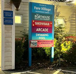a sign displaying entertainment options including a bar, restaurant, arcade, and swimming pool at Pure Village in Great Yarmouth