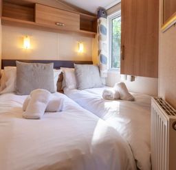 a bedroom with two beds and towels at Kelling Heath Holiday Park - Holiday Accommodation 18663, Holt