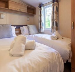 a bedroom with two single beds and a window at Kelling Heath Holiday Park - Holiday Accommodation 18663 in Holt