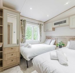 a bedroom with two beds and a wardrobe at Kelling Heath Holiday Park - Holiday Accommodation 18664 in Holt