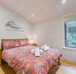a bedroom with a double bed, nightstand, and window at Kelling Heath Holiday Park - Holiday Accommodation 18691, Holt