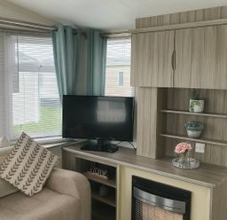 A living room with a sofa, tv, and shelves at Whitehouse Leisure Park - Holiday Accommodation 19055 Towyn, Abergele