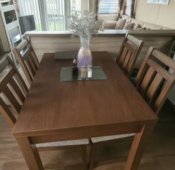 A dining table with chairs and a vase at Whitehouse Leisure Park - Holiday Accommodation 19057, Towyn, Abergele