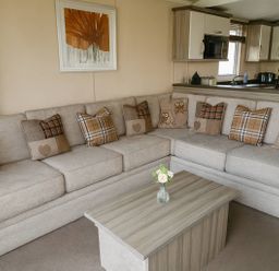A living room with a sofa, coffee table, and wall art at Whitehouse Leisure Park - Holiday Accommodation 19057, Towyn, Abergele