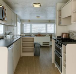 A kitchen with appliances and seating area at Golden Gate Holiday Centre - Holiday Accommodation 19058, Towyn