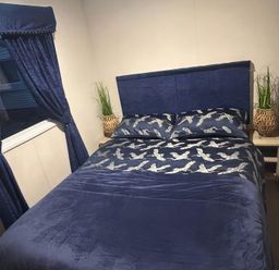 A bedroom with a bed and curtains at Presthaven Beach Resort - Holiday Accommodation 19166, Prestatyn