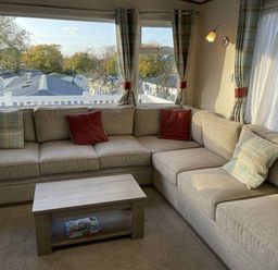 a corner seating area with cushions and a coffee table at Rockley Park - Holiday Accommodation 19386, Poole