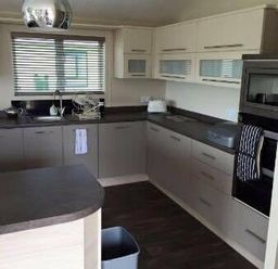 a kitchen with cabinets, countertop, and appliances at Hafan y Mor Haven - Holiday Accommodation 19898 in Pwllheli
