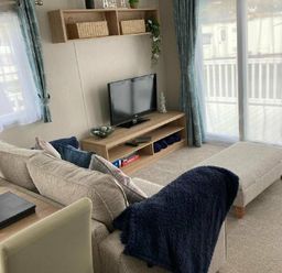a living room with a television on a shelf and a couch at Lyons Moelfre View - Holiday Accommodation 20226 Talybont