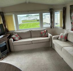 a seating area with two sofas and a television in a holiday caravan at Sand Le Mere Holiday Village - Holiday Accommodation 20326, Tunstall