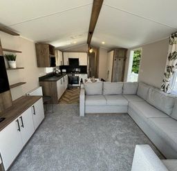 a living room with a sectional sofa and kitchen in Hafan y Mor Haven - Holiday Accommodation 20481 Pwllheli