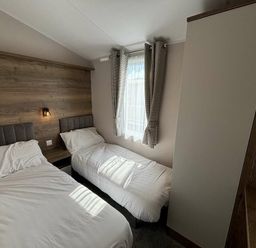 a bedroom with two beds and a window at Hafan y Mor Haven - Holiday Accommodation 20481 in Pwllheli