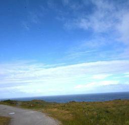 a coastal scene with a road leading to the ocean at Perran Sands - Holiday Accommodation 20514, Perranporth