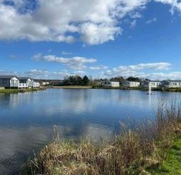 a lake surrounded by holiday homes at Lakeland Leisure Park - Holiday Accommodation 20788 in Flookburgh