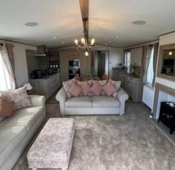 a living room with beige sofas and a coffee table at Lakeland Leisure Park - Holiday Accommodation 20788, Flookburgh