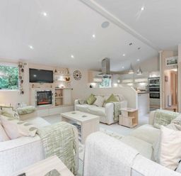 a living room with sofas and a kitchen area at Kelling Heath Holiday Park - Holiday Accommodation 20952 in Weybourne