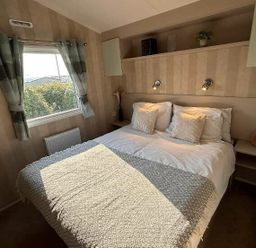 a bedroom with a double bed and shelves at Perran Sands - Holiday Accommodation 21088 in Perranporth