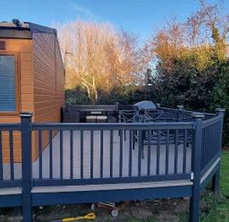 a deck with outdoor seating and a grill at Presthaven Beach Resort - Holiday Accommodation 21358 Prestatyn