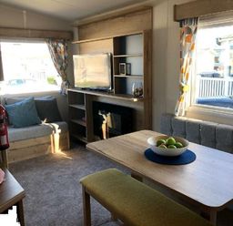 a living room with a television, seating area, and table at Greenacres Holiday Park - Holiday Accommodation 21467 Morfa Bychan