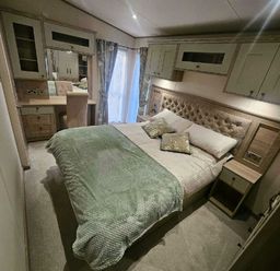 a bedroom with a large bed and wooden furniture at Tattershall Lakes Country Park - Holiday Accommodation 21501, Tattershall